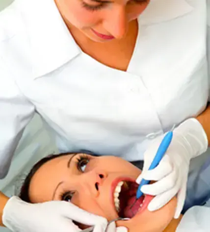 A hygienist examining a patient during a general dentistry checkup