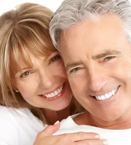 A couple smiling after restorative dental treatment
